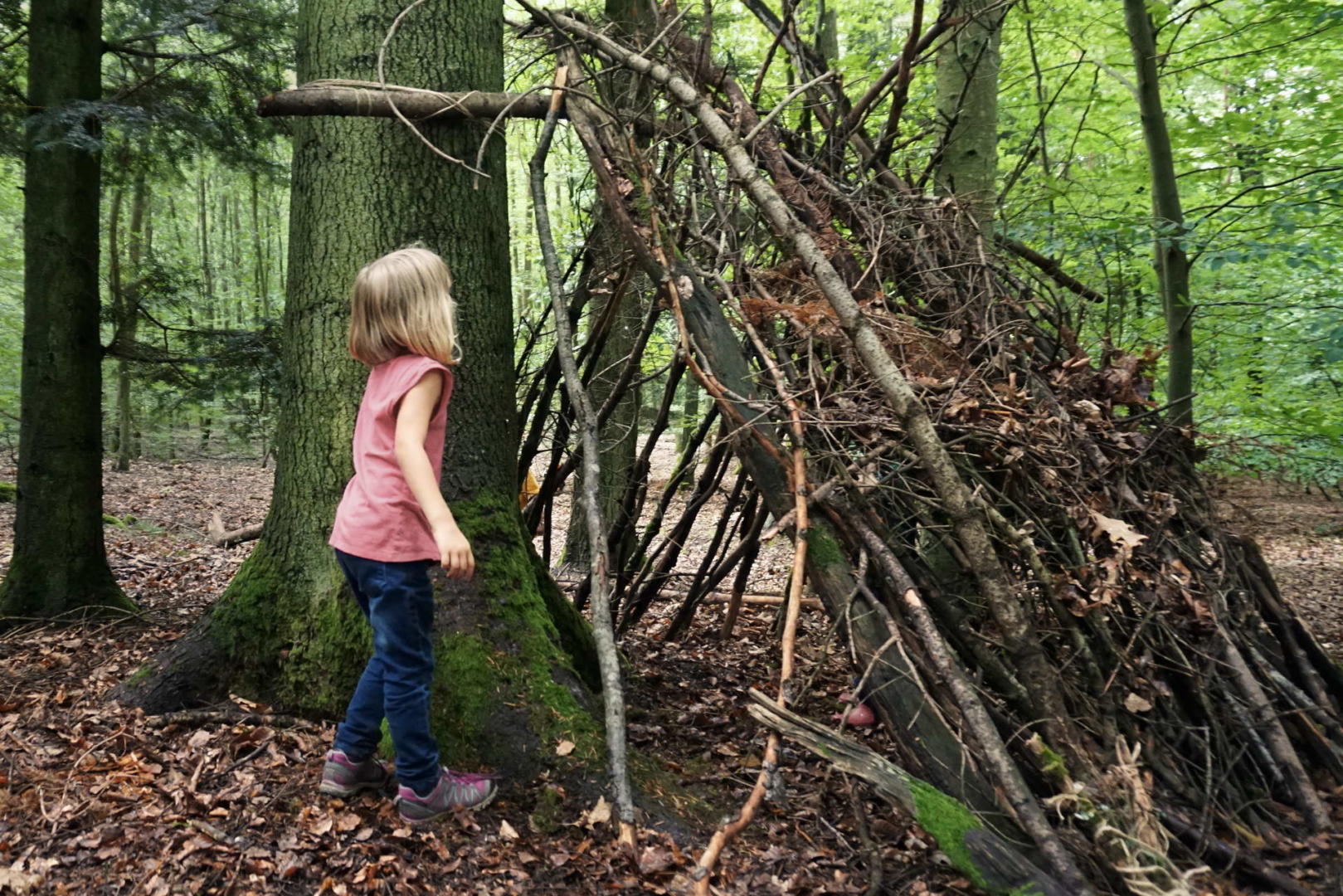 Selbstgebaute Waldhütte mit Mädchen
